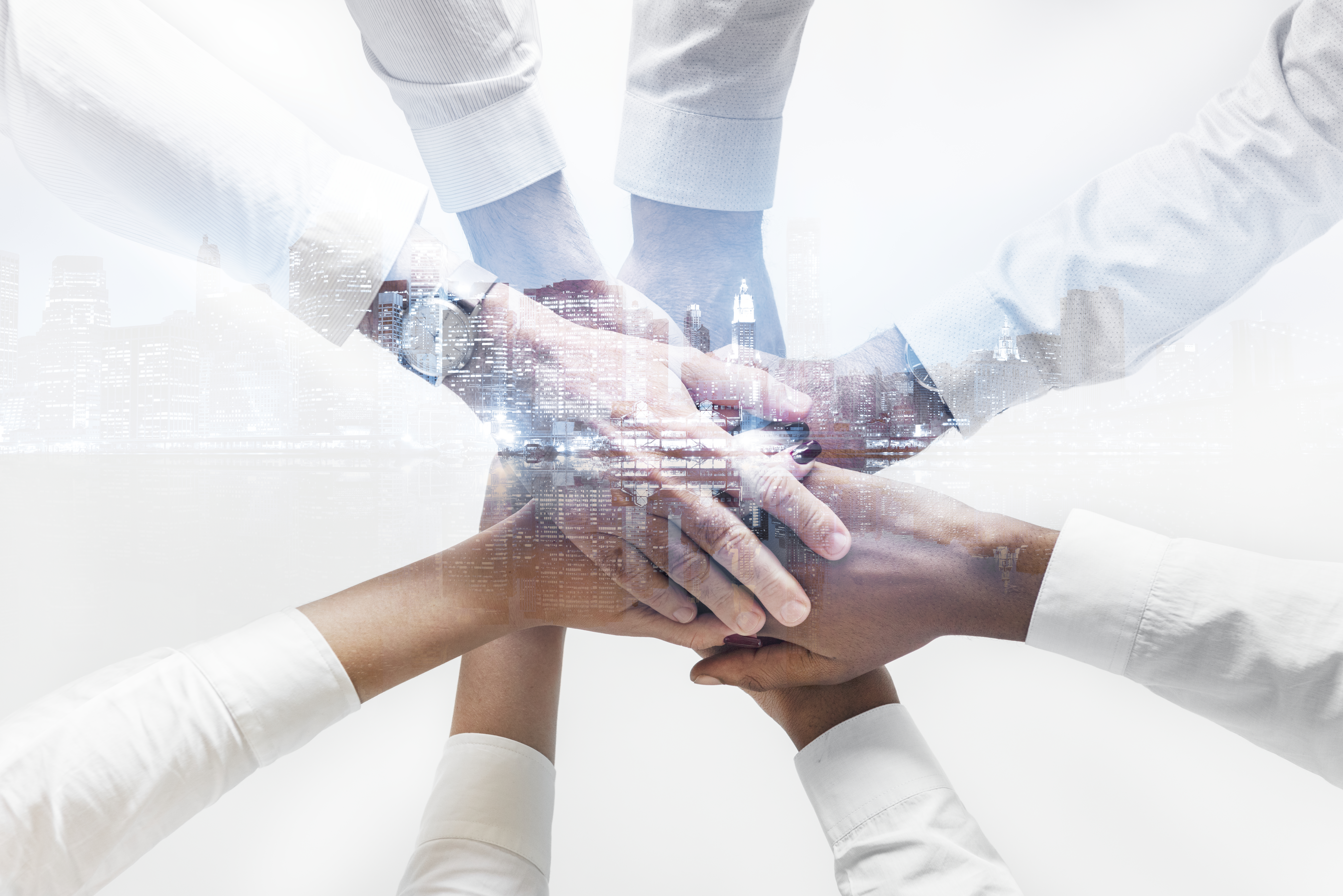 business team joining hands together city background